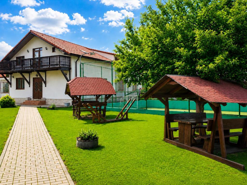 a yard with picnic tables and a house at Casa Bradul Inalt in Sohodol
