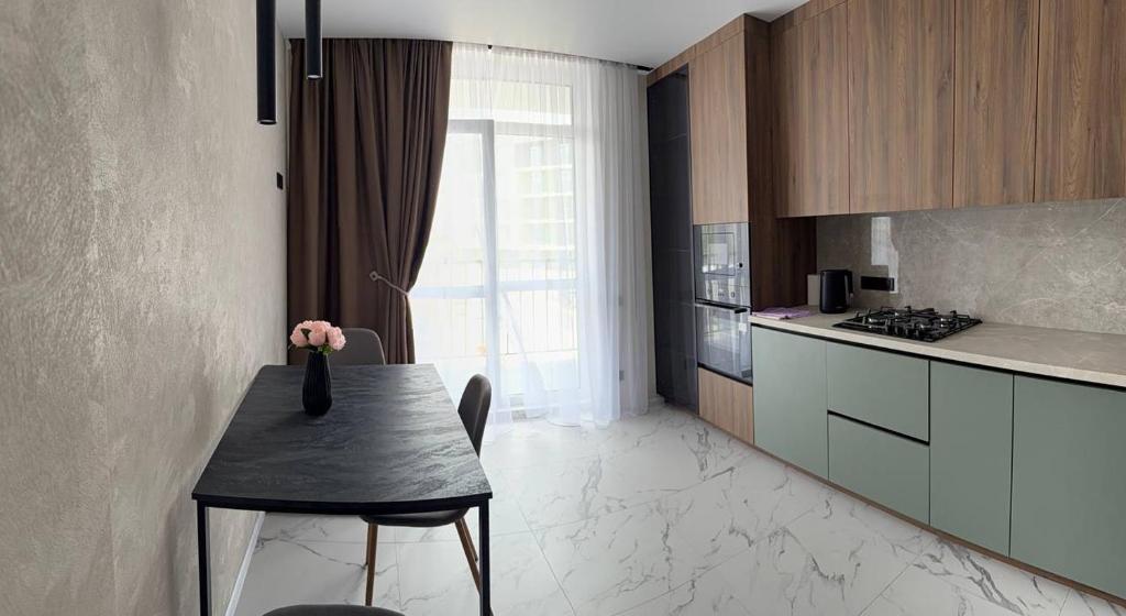 a kitchen with a table with a vase of flowers on it at Family 30 in Lutsk