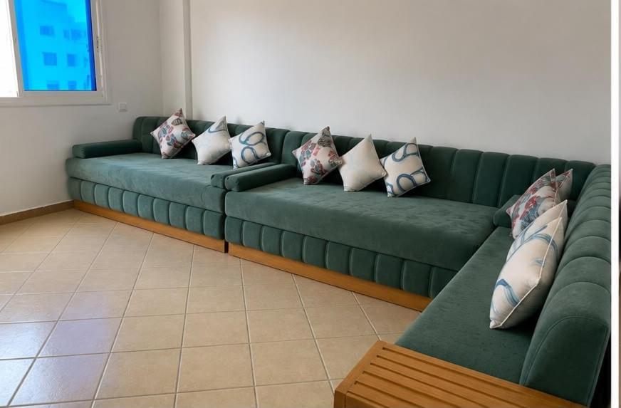 a green couch with pillows on it in a room at cosy and comfortable stay in Oued Laou