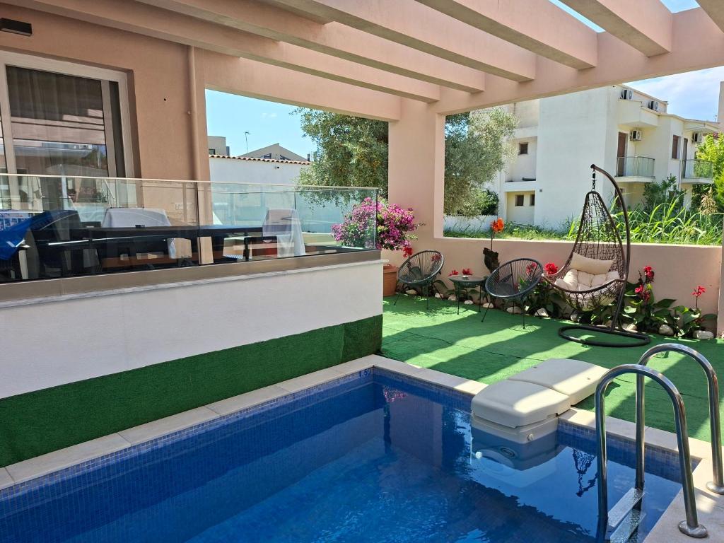 a house with a swimming pool and a patio at Emerald in Skala Rachoniou
