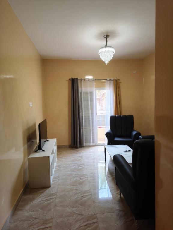a living room with a couch and a tv at Le Rivage de Sérénité in Sali Nianiaral