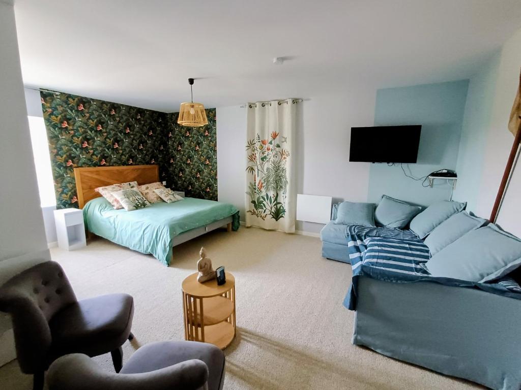 a living room with a couch and a bed at Chambre d'hôte ColChris in Saint-Pierre-le-Vieux