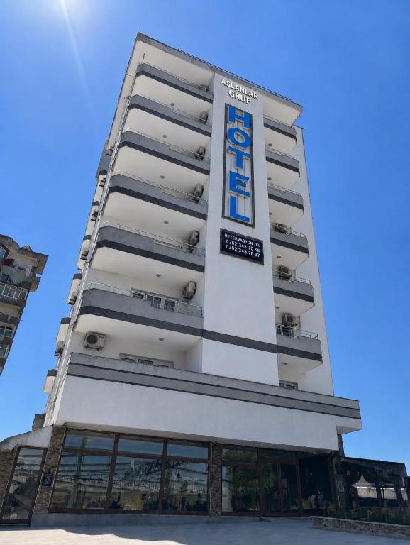 a tall white building with a sign on it at Aslanlar Otel in Tekirdağ