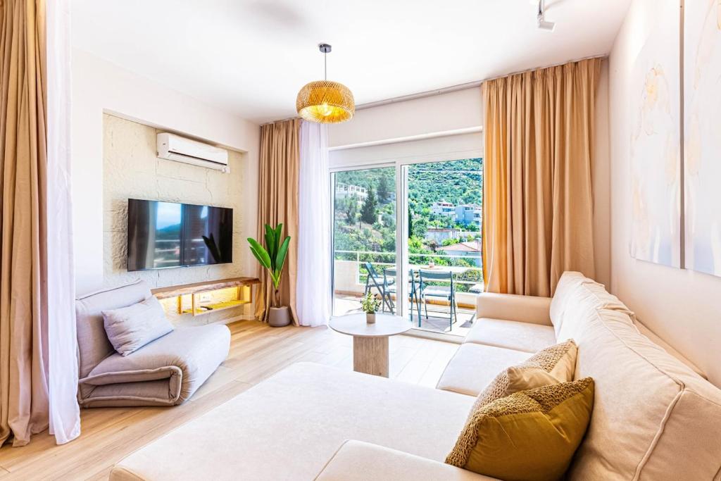 a living room with a couch and a tv at Dhermi's Icon Big 1BR Apt 10 in Dhërmi
