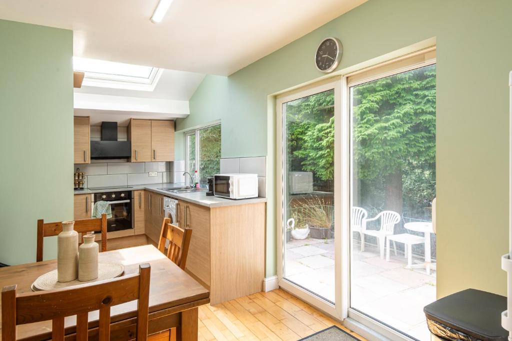 a kitchen and dining room with a table and a window at Spacious 3BR Family Home with Big Garden in Manchester