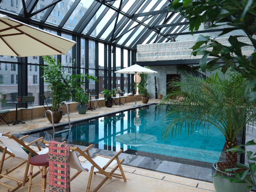 a swimming pool in a building with a glass ceiling at Belle Guldsmeden in Aarhus