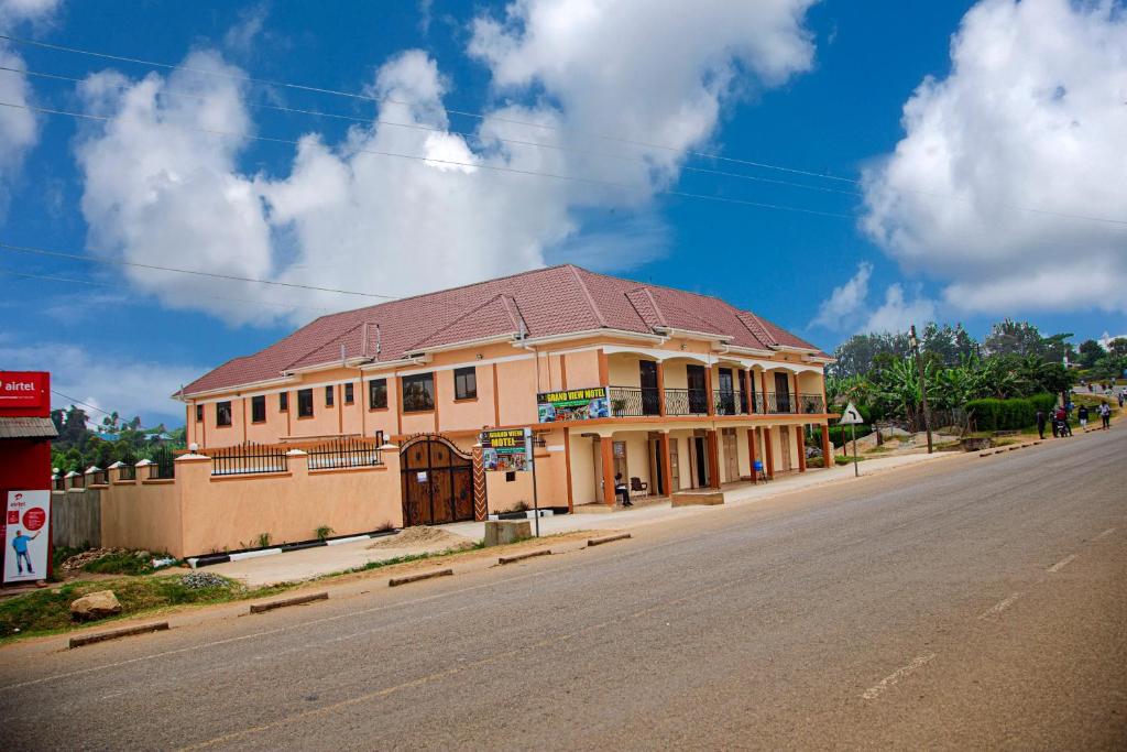 a building with a brown roof on the side of a street at Grand View Hotel in Fort Portal
