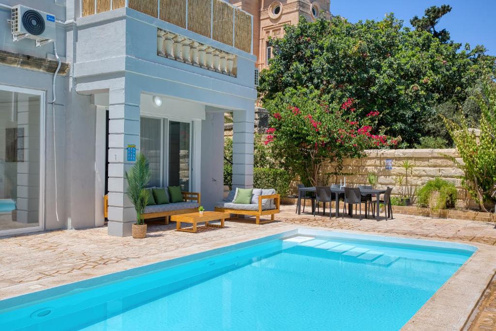 a house with a swimming pool and a patio at Stunning villa w Private pool TT table Sleeps 14 in St. Julianʼs
