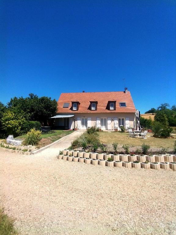 a large house with a red roof on a field at L'épi de blé in Saint-Astier