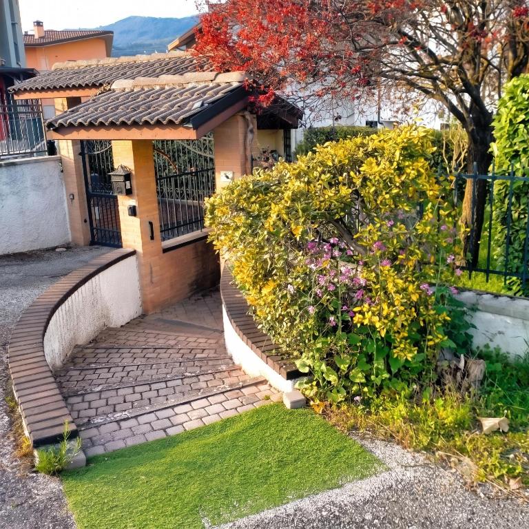 a house with a brick walkway in front of a garden at Casa dei Nipotini con Posto Auto Riservato in Paganica