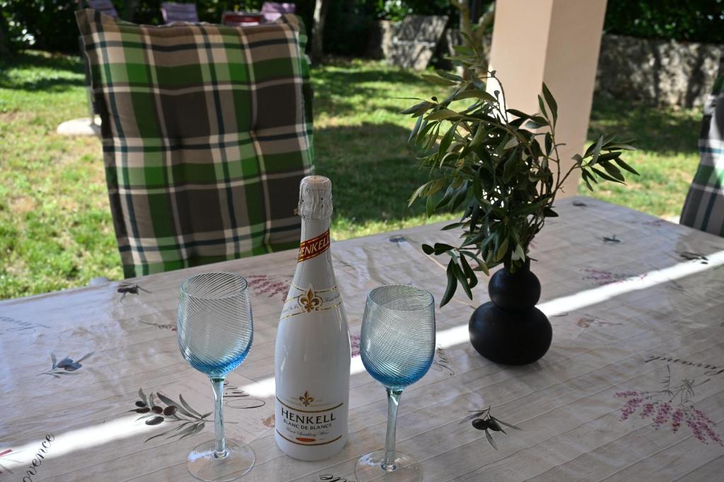 a bottle of champagne sitting on a table with two wine glasses at Apartma Mija - XL in Kornić