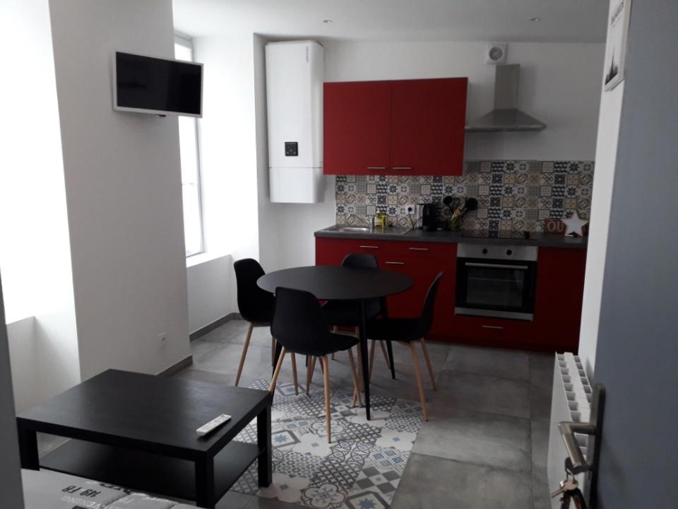 a kitchen with red cabinets and a table and chairs at cosy à Blois in Blois