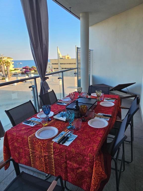 a table with plates and glasses on top of a balcony at Holidaysshogun 2 in Lido di Ostia