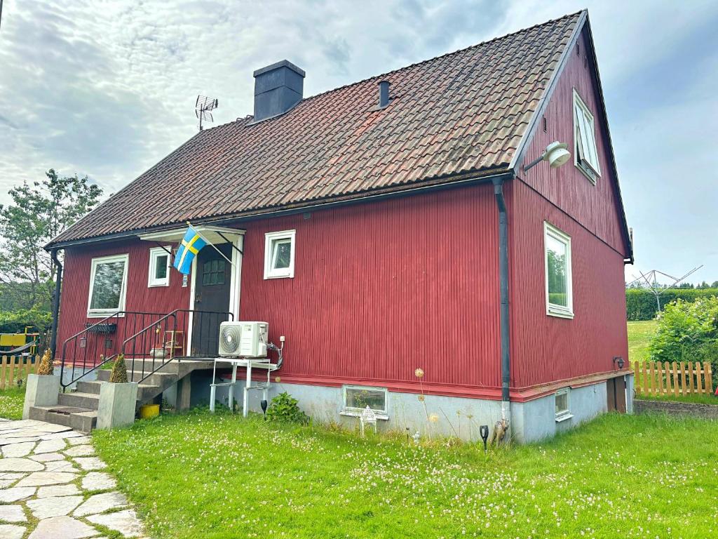 a red house with a flag on the front of it at Hus Gillberga in Varmlands Nysater