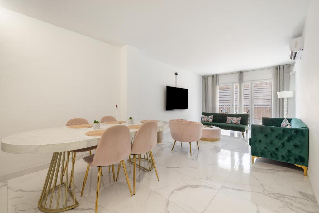 a white living room with a table and chairs at Apartamento Calafell Mar in Calafell