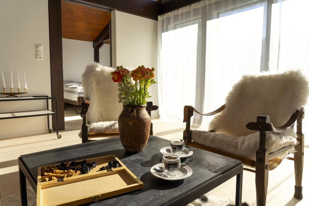 ein Wohnzimmer mit einem Tisch und einer Blumenvase in der Unterkunft Alpstern in Wildhaus