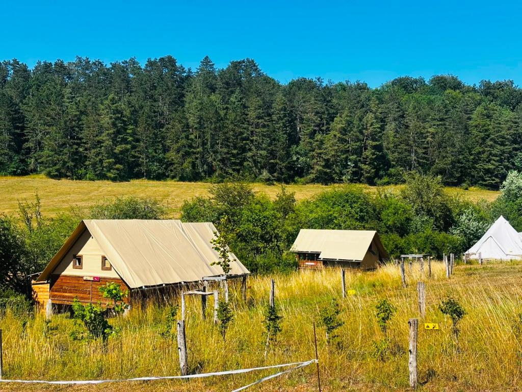 an old house and a barn in a field at Ecodomaine Chemins de Traverse in Auberive