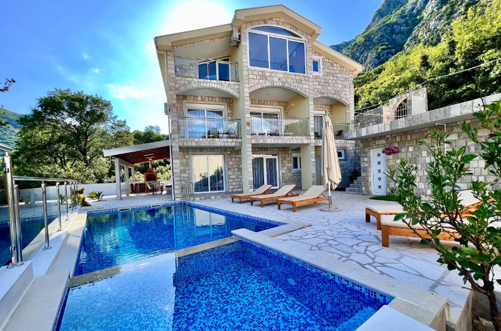 a villa with a swimming pool and a house at Villa Maki in Donji Morinj