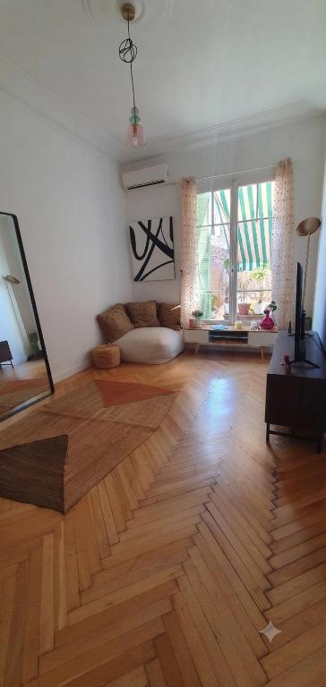 a large living room with a wooden floor at Dolce bilocale con terrazzo in Nice