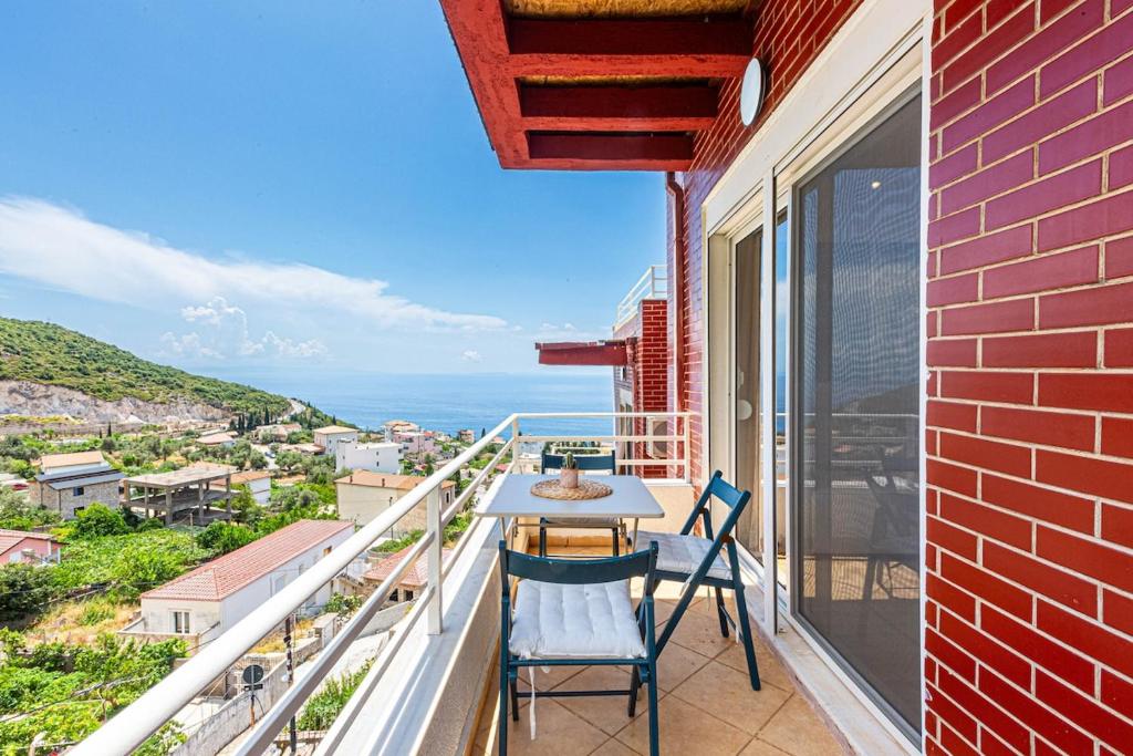 a balcony with a table and chairs and the ocean at Dhermi's Icon Big 1BR Ap 15 in Dhërmi