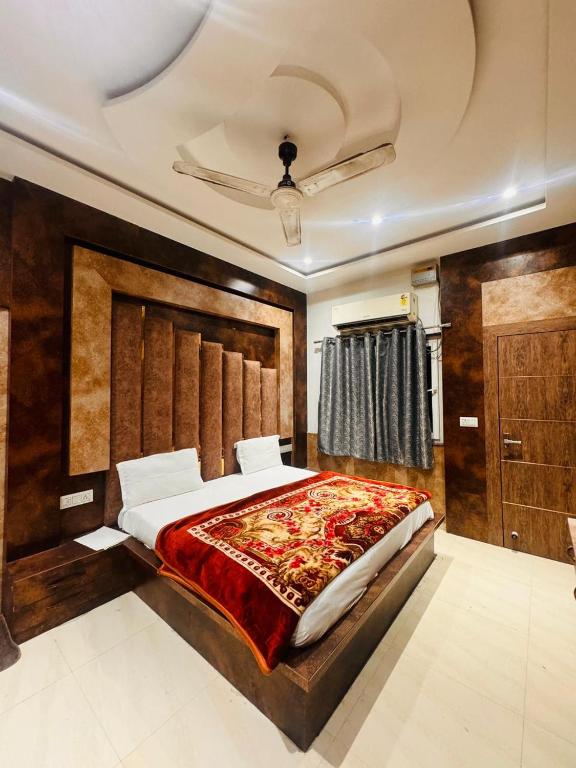a bedroom with a large bed with a wooden headboard at Hotel rexa in Vrindāvan
