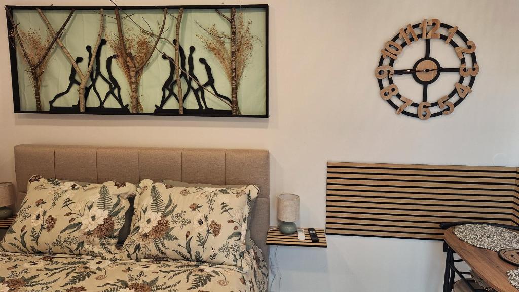 a bedroom with a bed and a clock on the wall at Studio Miška in Bohinjska Bela