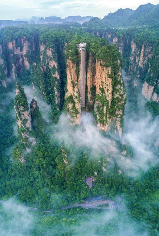 an aerial view of a mountain in the clouds at Zhangjiajie Cloudscape Courtyard Hotel-Vegan Available, Chinese Retro Style,Tea Culture Experience, Free Breakfast ,Travel Guide& Book Tickets,Friendly Host,Orient esthetics in Hanqiyu