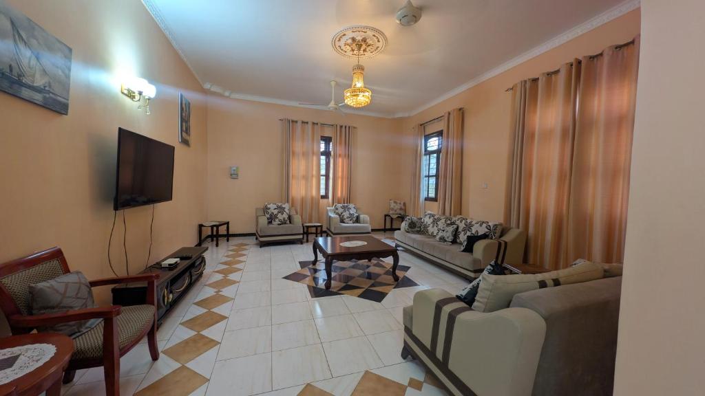 a large living room with couches and a tv at Furaha House in Chukwani