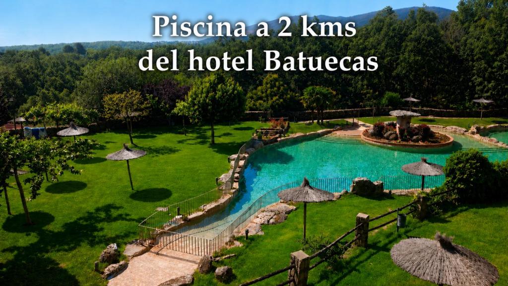 a resort with a swimming pool with a fountain at Hotel Batuecas in La Alberca