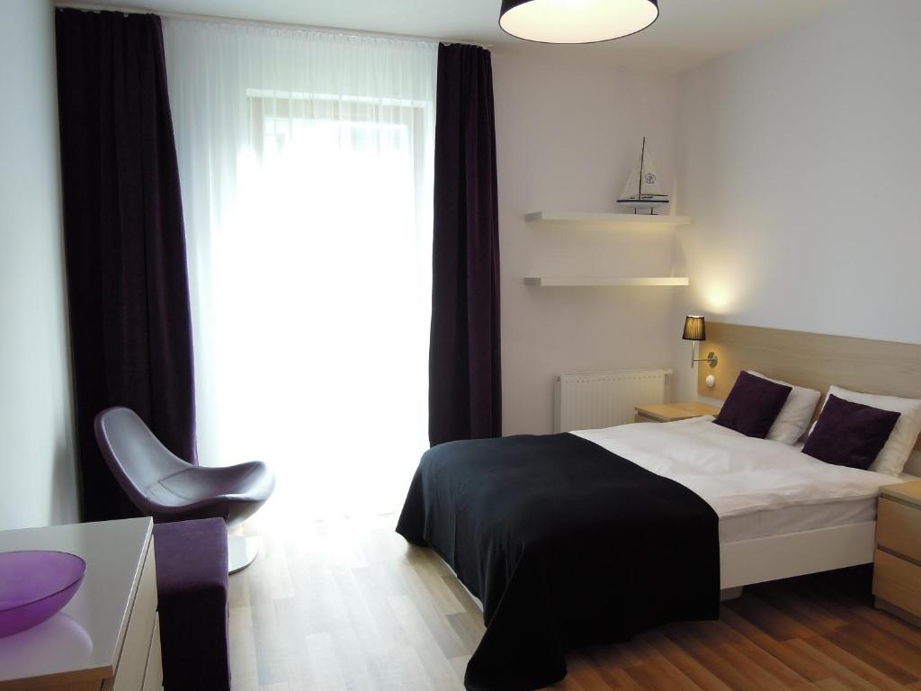 1 dormitorio con cama, escritorio y ventana en Apartamenty Karawela - Nadmorski Dwór, en Gdansk