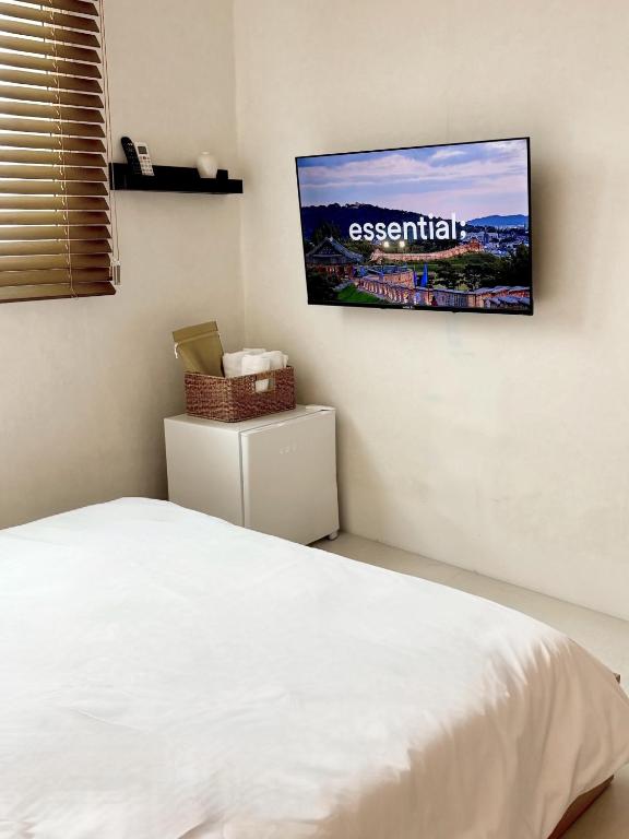 a bedroom with a bed and a tv on the wall at 브릭스테이 brikstay in Gyeongju