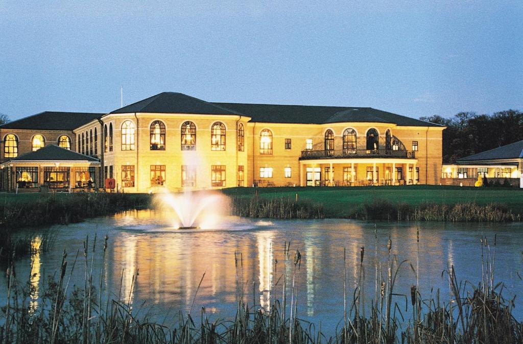 a large building with a fountain in the middle of a pond at Belton Woods Hotel, Spa & Golf Resort in Grantham