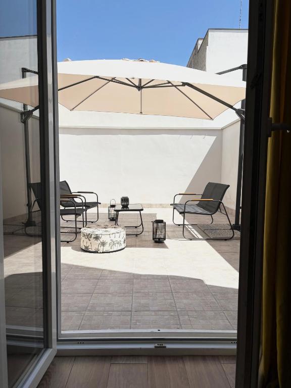 a patio with tables and chairs and an umbrella at Il Canto Quinto in Acquaviva delle Fonti