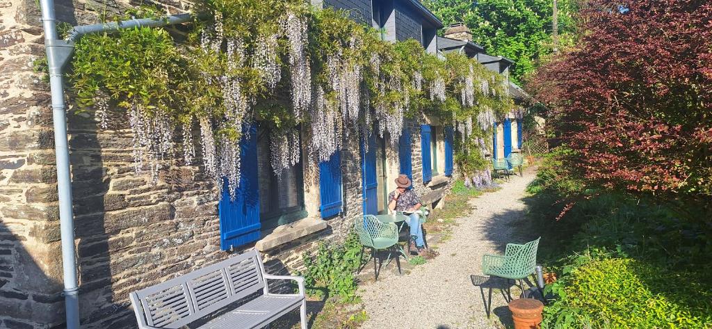 a man standing outside of a blue building with chairs at B&B at Stang Korvenn in Laz