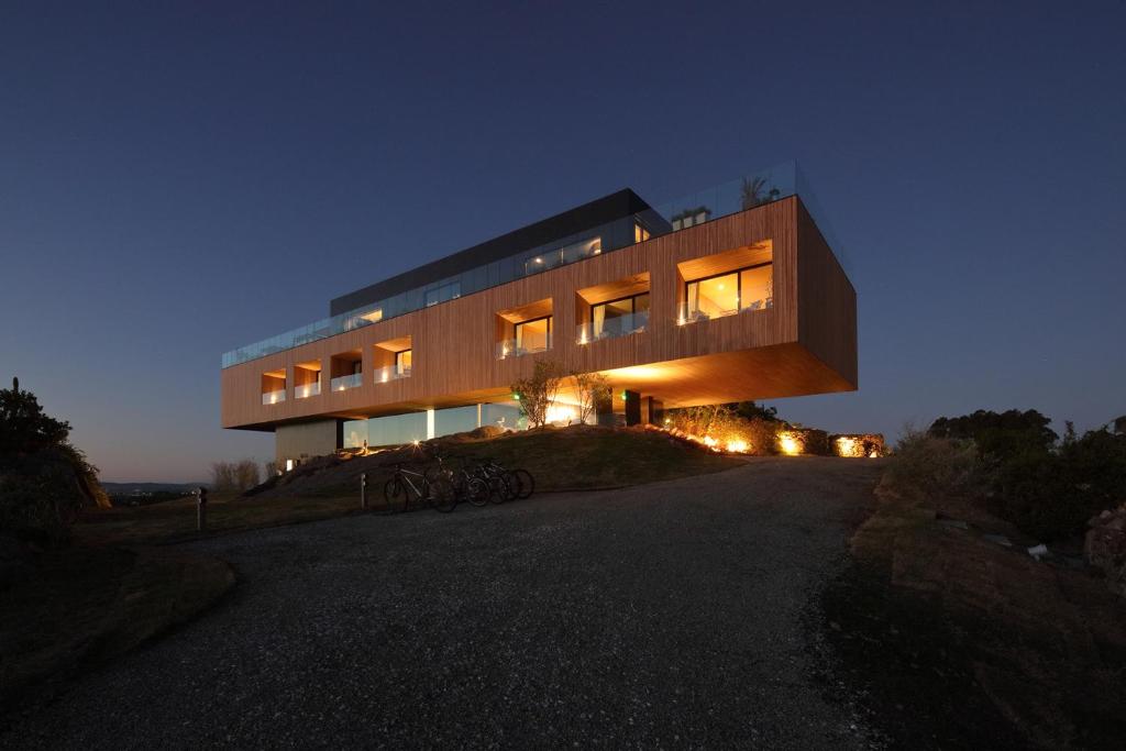 uma casa no topo de uma colina à noite em Hotel Fasano Punta del Este em Punta del Este