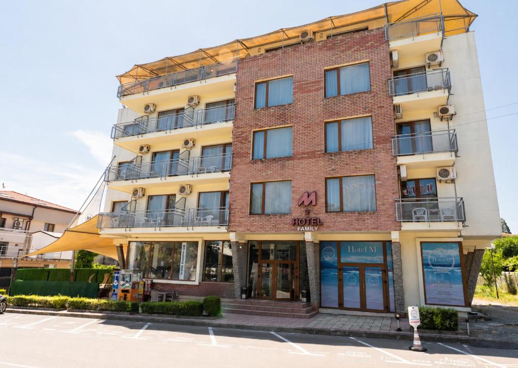 a tall brick building on the corner of a street at Hotel M2 in Primorsko