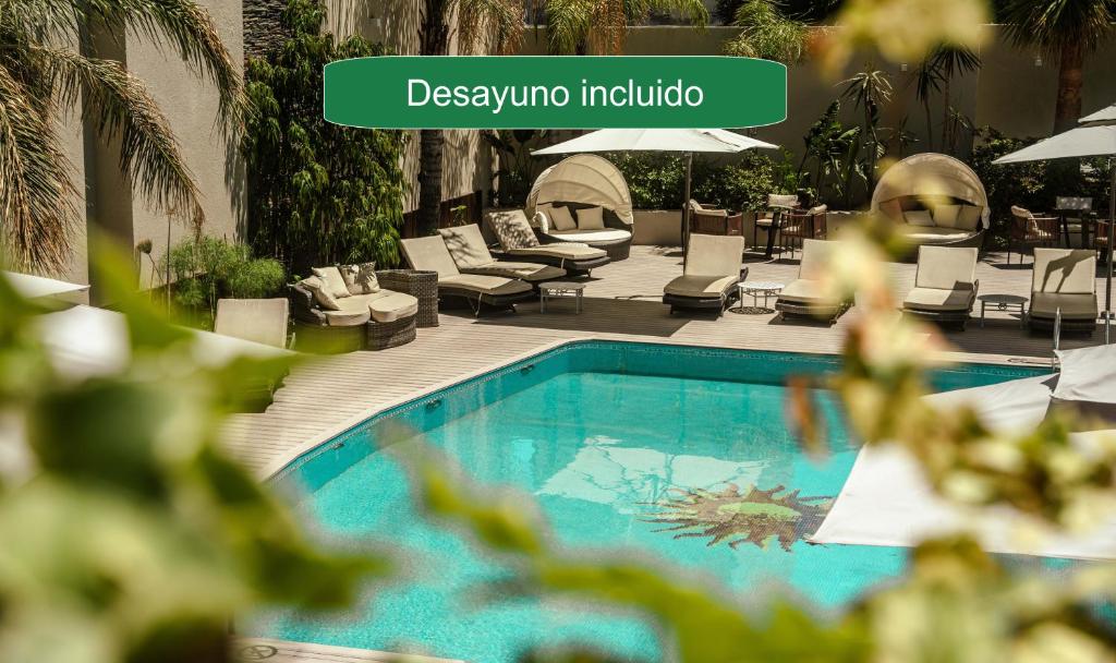 a swimming pool with lounge chairs and a hotel at Holiday Inn Rosario by IHG in Rosario