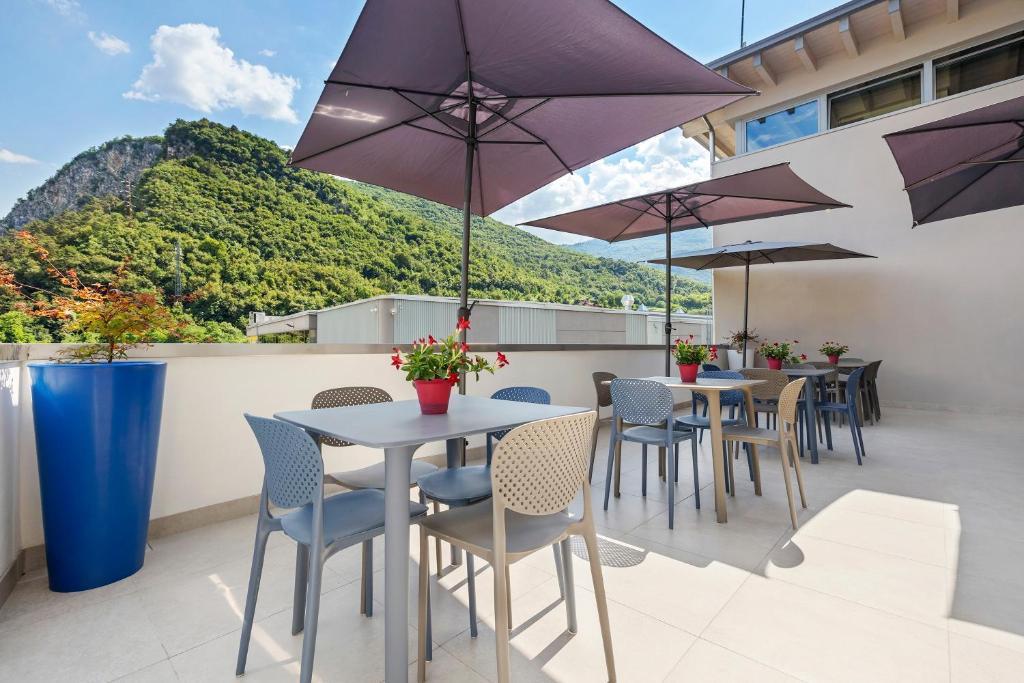 a row of tables and chairs with umbrellas on a balcony at Cameras Mori in Mori