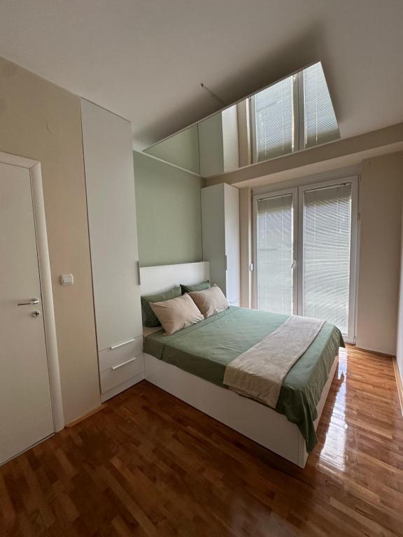 a bedroom with a bed and a large window at Zen Apartment in Kumanovo