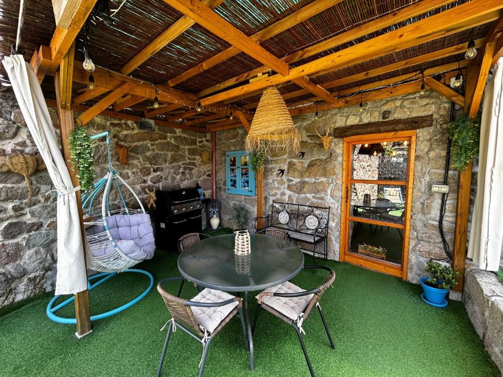 a patio with a table and chairs and a grill at Rincón del Viso in Ourense