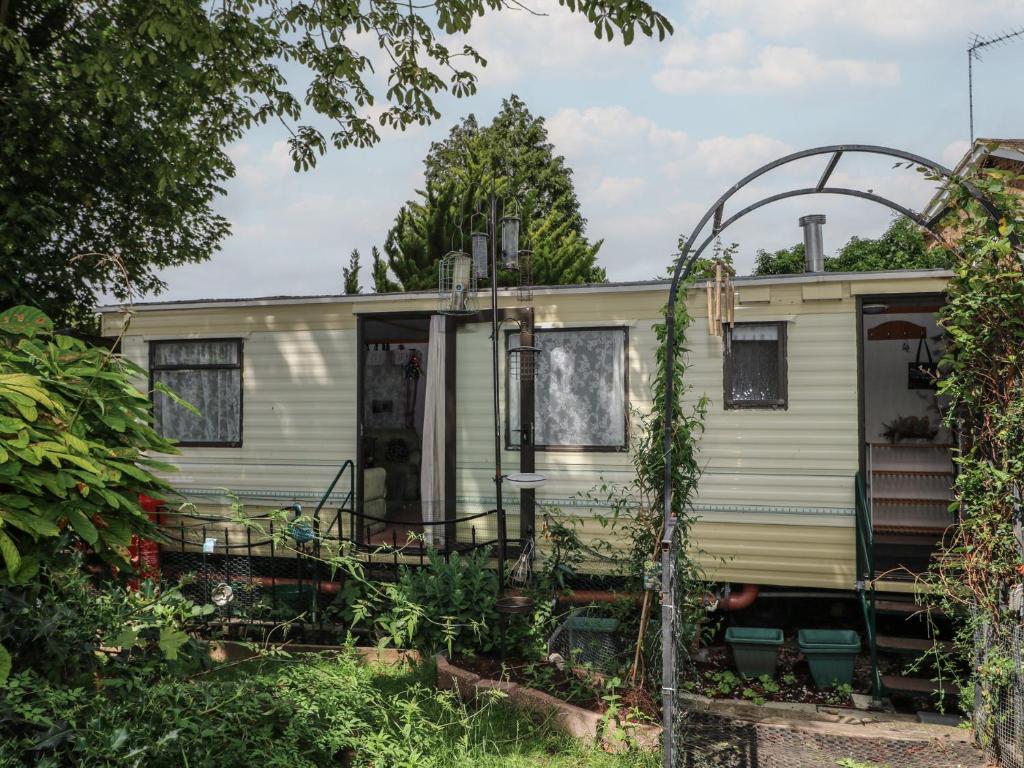 an old caravan in a garden with an arbor at 10 Cater Gardens in Guildford