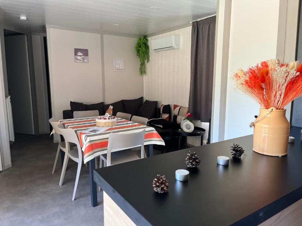 a living room with a table and a couch at CHALET 10 chaleureux tout confort dans domaine avec Piscine au cœur des Landes bord de Lac avec plage aménagée in Labouheyre