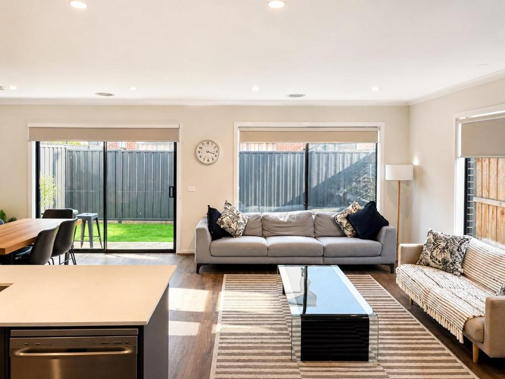 a living room with a couch and a table at Modern Family Home in Truganina - Space to Relax in Truganina