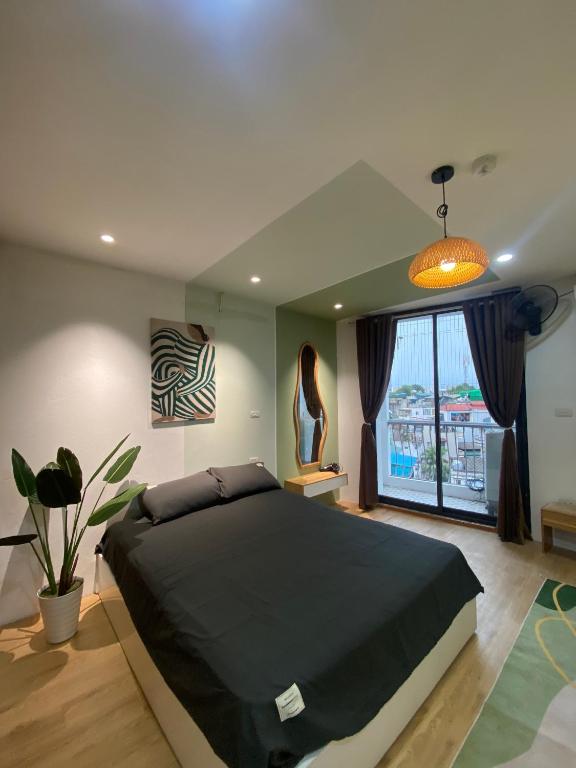 a bedroom with a large bed and a large window at Little House Đông Tác in Hanoi