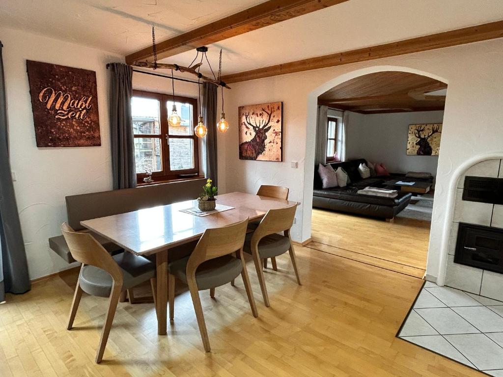 a dining room and living room with a table and chairs at Habicht Ferienhaus in Arnbruck
