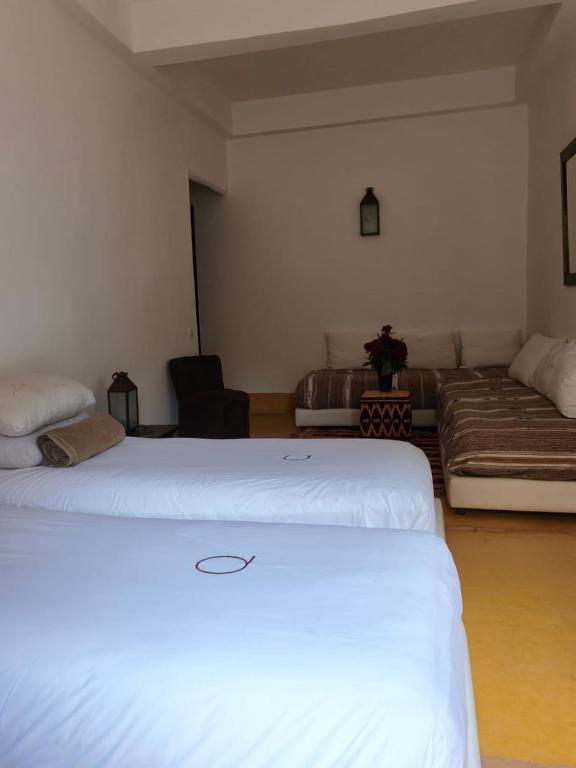 a hotel room with two beds and a couch at Ecolodge Quaryati Marrakech in Douar Tounsi