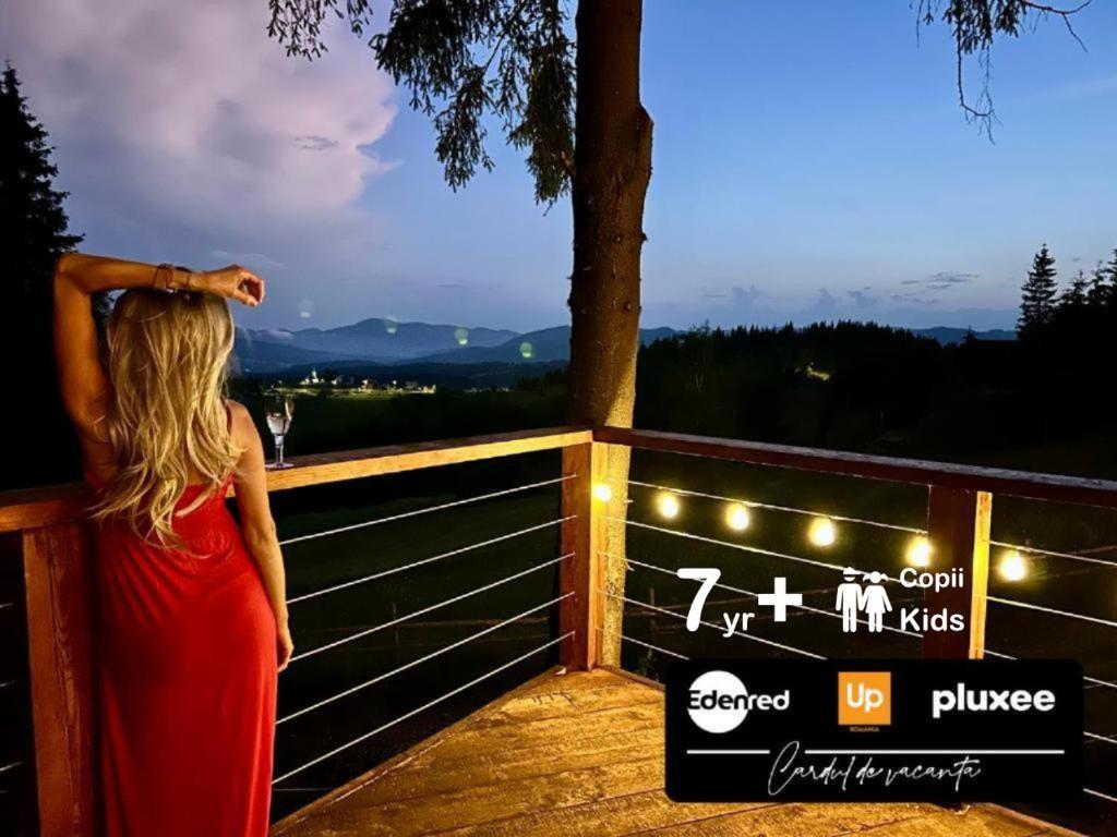 a woman in a red dress looking at a sign at Tiarra Mountain Lodge in Beliş