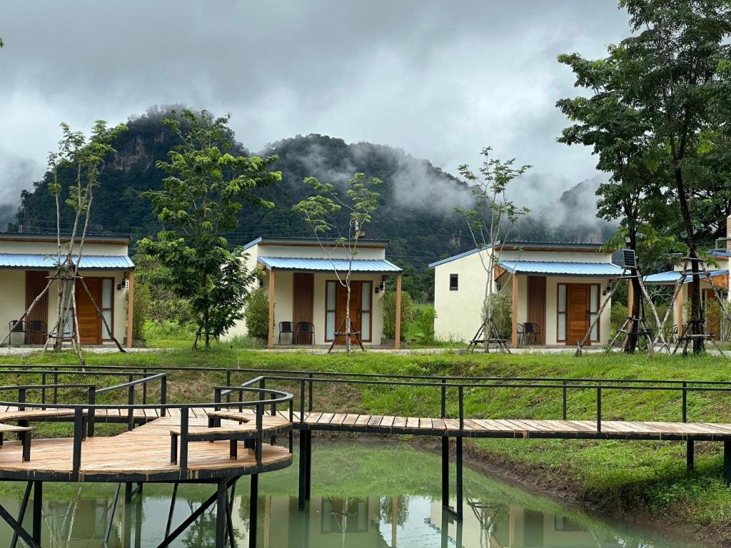 a house with a wooden bridge in front of a mountain at Openview Resort Thakhek in Thakhek