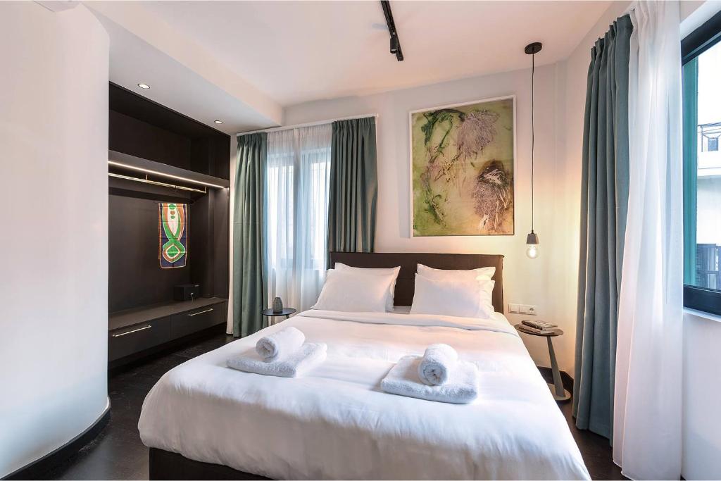 a bedroom with a large white bed with towels on it at Sarri 2 by Stay Unique in Athens