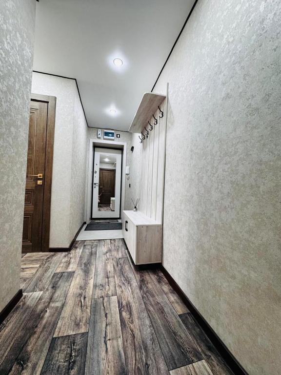 an empty hallway with wood floors in a building at Квартира in Temirtaū